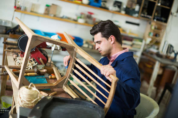 man working on chair in upholstery shop