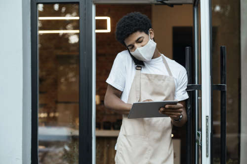 African-American man in apron taking business call