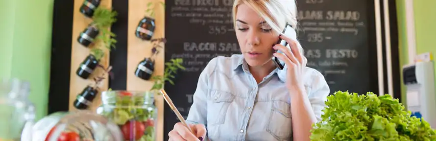 restaurant owner writing notes while on phone call