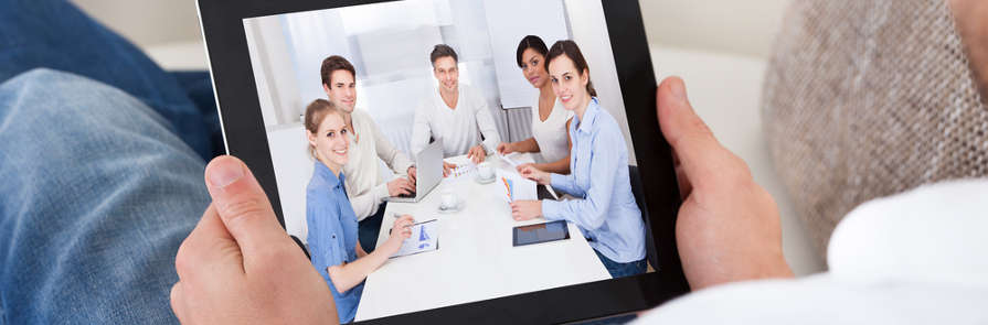 Person participating in virtual business meeting through tablet