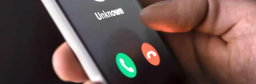 hand holding phone with unknown caller alert on screen