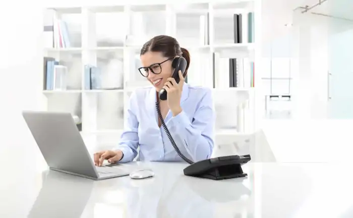receptionist on voip phone working on laptop