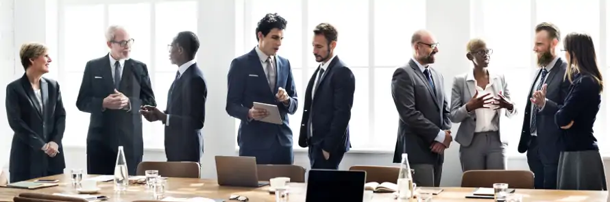 group of business executives in small groups at meeting