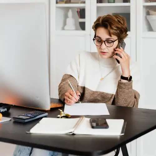 woman talking on cell phone in home office