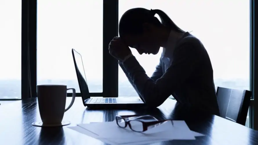 stressed businesswoman resting her head against her hands