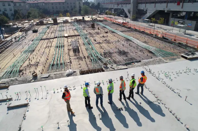 construction crew overlooking cables stretching across building footprint
