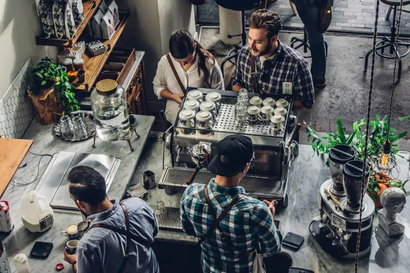 overhead shot of couple waiting for coffee drinks while baristas work
