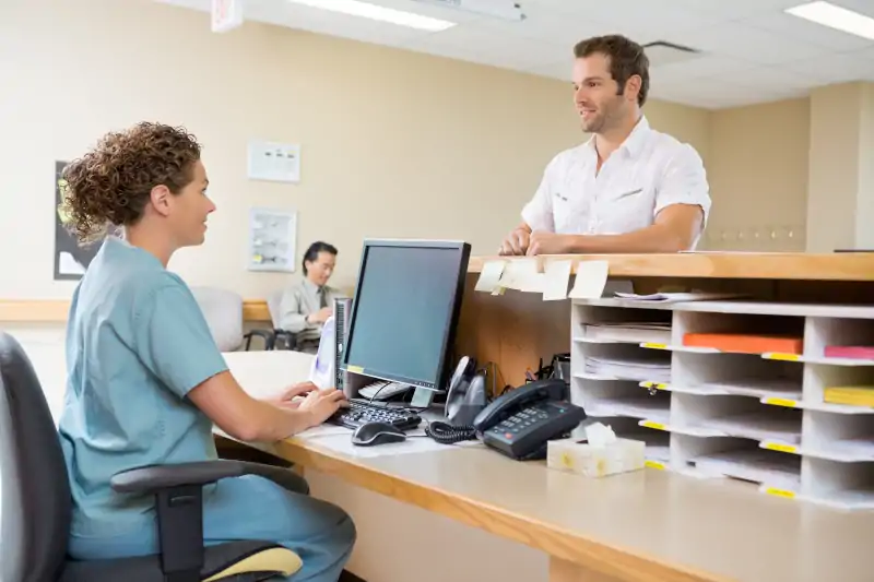 intake nurse speaking with patient at desk