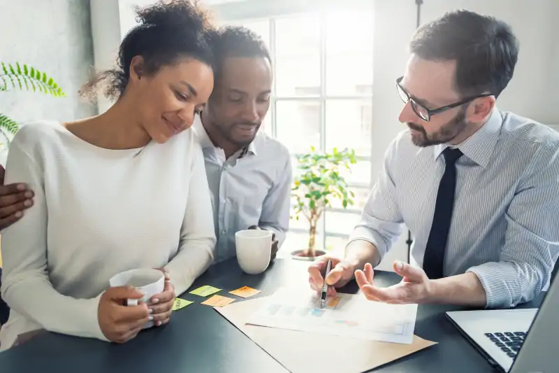 insurance agent going over policy with young couple