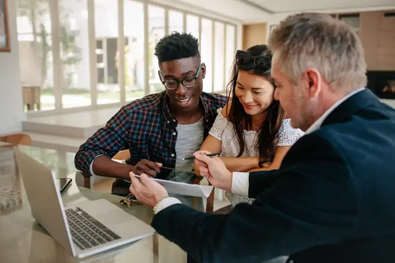 realtor going over paperwork with young couple