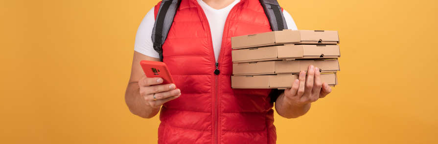 man holding cell phone and pizza boxes