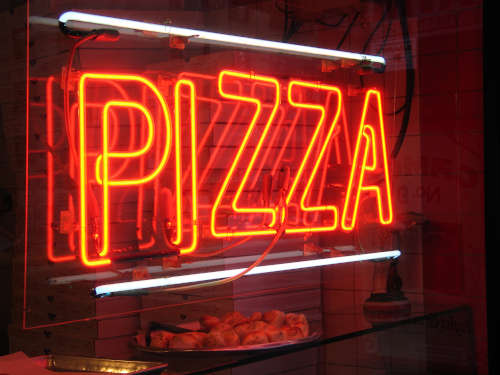 Neon restaurant sign reading "pizza"