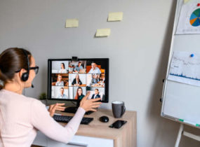woman sitting at desk videoconferencing while working from home