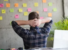 entrepreneur staring at post-it notes on concrete wall