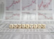 inflation written in blocks in front of stock graphs