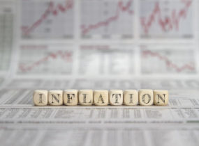 inflation written in blocks in front of stock graphs