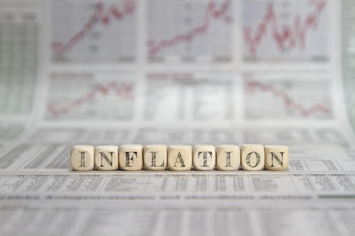 inflation written in blocks in front of stock graphs