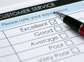 paper customer service survey with excellent checked in ink and a pen lying on top