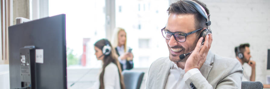 smiling white man on headset in office